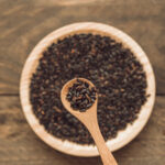black-organic-rice-grain-spoon-bowl-wooden-backdrop